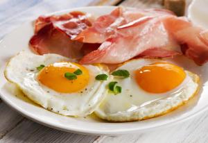 two eggs and bacon on a plate on a table at The Rodney in Martley