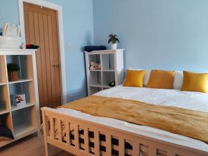 um quarto com uma cama com almofadas amarelas e brancas em Lytham Luxury em Saint Annes on the Sea