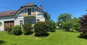 a blue and white house with bushes in the yard at derHofRat in Litzelsdorf