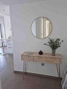 a dressing table with a mirror on a wall at Acogedor apartamento con piscina in Águilas