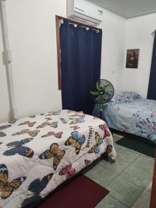 a bedroom with a bed with a butterfly quilt at Tortuguero Casa de Playa Green House in Tortuguero