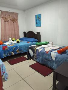 a bedroom with two beds with stuffed animals on them at Tortuguero Casa de Playa Green House in Tortuguero