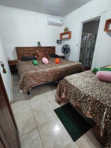 Habitación con 2 camas con sábanas de guepardo en Tortuguero Casa de Playa Green House en Tortuguero