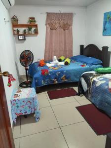 a bedroom with two twin beds and a table at Tortuguero Casa de Playa Green House in Tortuguero