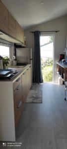 a kitchen with wooden cabinets and a large window at Baia 1 in Drammont +13 photos