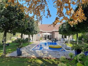 a house with a swimming pool with a yellow boat in it at luxe villa met privé zwembad en jacuzzi in Zeewolde