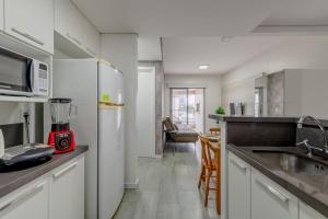 a kitchen with white cabinets and a blender on the counter at Trend NCG - Apartament 1602 in Porto Alegre