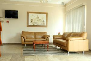 a waiting room with two leather couches and a table at Candeias Hotel in Batatais