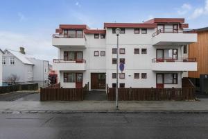 a large white building with a fence in front of it at Cheerful 3BR Down Town Newly Renovated in Reykjavík