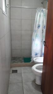 Un baño con inodoro y cortina de ducha. en turismo chascomus, en Chascomús 14 fotos más