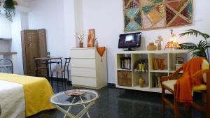 Cette chambre comprend un lit, une télévision et une table. dans l'établissement Estudio con encanto en la Carihuela, à Torremolinos