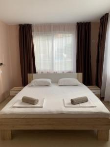 ソゾポルにあるVilla Rouge - Apartment Victoriaの大きなベッドとタオル2枚のある寝室