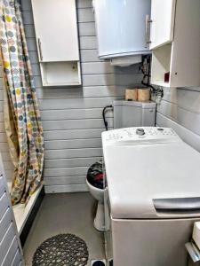 La petite salle de bains est pourvue de toilettes et d'un lavabo. dans l'établissement Tiny White Home (Self Check-In), à Bucarest
