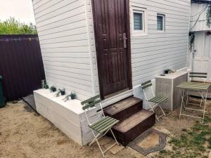 two chairs and a door on a house at Tiny White Home (Self Check-In) in Bucharest