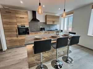 una cocina con una isla con mesa y sillas en Superbe appartement neuf et cosy 77 m2, en Villers-le-Lac
