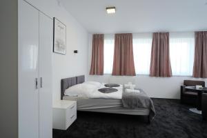a bedroom with a bed with white sheets and pillows at Apartmani NAN in Visoko