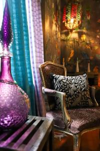 a purple vase sitting on a table next to a chair at Boutique hotel and gallery in San Angel Inn in Mexico City