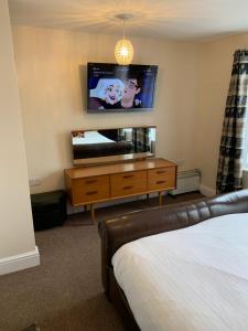 a bedroom with a bed and a tv on the wall at delamere holiday apartments in Blackpool