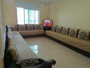 - un salon avec un canapé et une télévision dans l'établissement Appart el bassatine pr famille, à Meknès