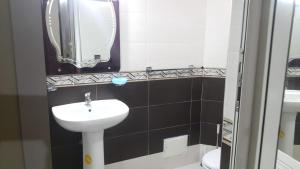 ein Badezimmer mit einem Waschbecken, einem Spiegel und einem WC in der Unterkunft Appart el bassatine pr famille in Meknès