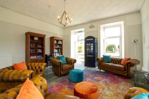 a living room with leather couches and a coffee table at Cosy Wolf Bed & Breakfast in Freshwater