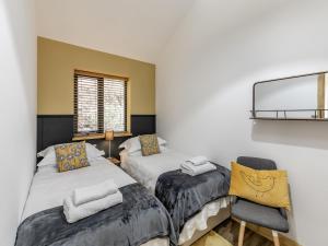 a bedroom with two beds and a mirror and a chair at Shutlingsloe in Mellor