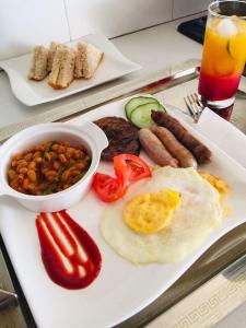 a plate of food with eggs sausage beans and vegetables at Antique Home BnB in Gaborone