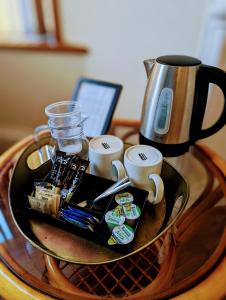 a tray with cups and a coffee maker on a table at The Coo's Guest House in Inverness