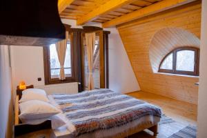 a bedroom with a bed and two windows at Conacul Drahneilor in Ruscova