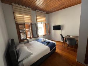 a bedroom with a bed and a desk and window at İnkaya hotels in Yıldırım