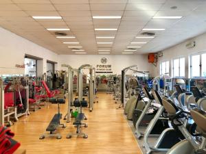 un gimnasio con muchos equipos cardiovasculares en una habitación en ForumGuestHouse Center Parking, en Parma