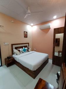 Hotel Greenoz في جايبور: غرفة نوم مع سرير أبيض كبير في غرفة