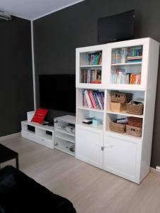 a white book shelf with books and a flat screen tv at 4 bedroom flat in the heart of Oslo in Oslo