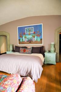 a bedroom with two beds and a painting on the wall at Gallery and Boutique BNB in San Angel Inn in Mexico City