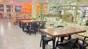 a restaurant with wooden tables and chairs and plants at Flat no Aldeia das Águas Park Resort in Barra do Piraí