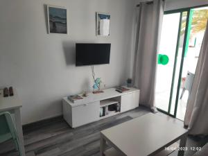 ein weißes Wohnzimmer mit einem TV an der Wand in der Unterkunft Precioso y céntrico apartamento in Costa Teguise
