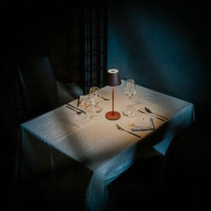 a table with wine glasses and a lamp on it at Agriturismo Podere Tovari in Anghiari