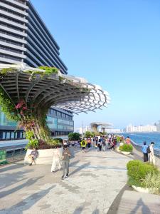 a group of people walking on a sidewalk next to a building at L'Escale in Hong Kong