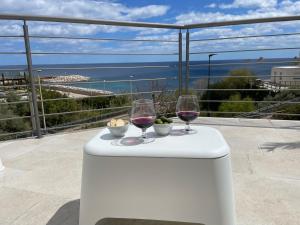 dos copas de vino en una mesa con vistas al océano en Sea House IUN Q7317, en Santa Maria Navarrese