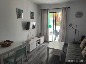 ein Wohnzimmer mit einem Sofa und einem Tisch in der Unterkunft Precioso y céntrico apartamento in Costa Teguise