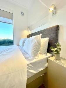 a bedroom with a white bed with a window at Hermanus Sea Breeze in Hermanus