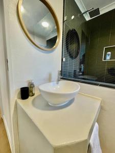 a bathroom with a bowl sink and a mirror at Hermanus Sea Breeze in Hermanus