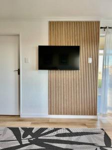 a living room with a flat screen tv on a wall at Hermanus Sea Breeze in Hermanus