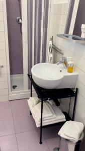 a white bathroom with a sink and a shower at B&B Persi Nel Sud, Pozzallo in Pozzallo