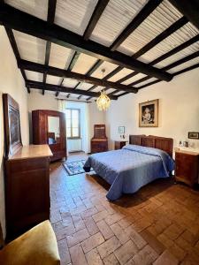 a large bedroom with a bed and a chandelier at La Casa del Castello in Montemerano