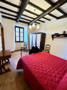 a bedroom with a large red bed in a room at La Casa del Castello in Montemerano