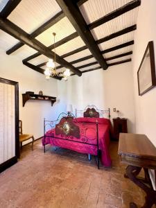 a bedroom with a pink bed in a room at La Casa del Castello in Montemerano