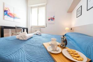 ein blaues Bett mit einem Tablett mit Keksen darauf in der Unterkunft Casa Dalia Terrazze Relax e WiFi in Santa Margherita Ligure