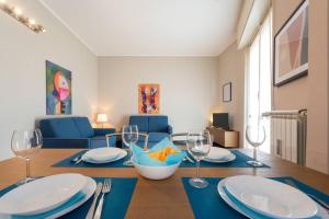 ein Esszimmer mit einem Tisch mit Tellern und Weingläsern in der Unterkunft Casa Dalia Terrazze Relax e WiFi in Santa Margherita Ligure