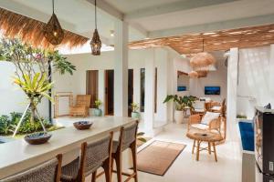 een keuken en een woonkamer met een tafel en stoelen bij Villa Matahari Cosy&stylish 3BR private villa 10mins to Finns Beach in Canggu